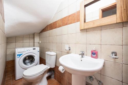 a bathroom with a toilet sink and a washing machine at Villa Neria in Áptera