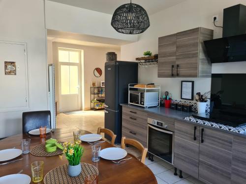 a kitchen with a table and a dining room at Dors Fée Duplex avec Toit-Terrasse et Salle de Jeux - Centre Bourg à 4 min du Puy duFou in Les Épesses