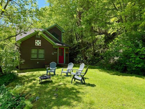 eine Gruppe von Stühlen und einem Tisch vor einem Haus in der Unterkunft Tubing, Hiking and Jay Peak fun at the Cliff House in Montgomery