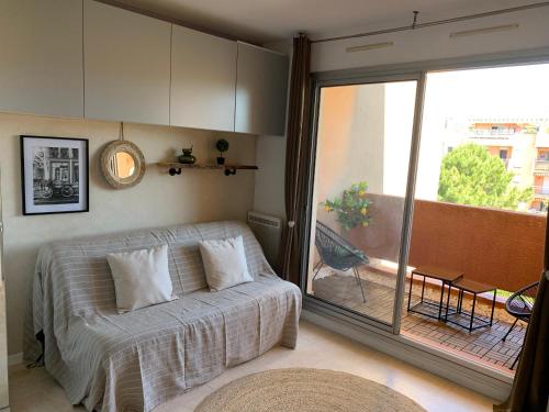 une chambre avec un lit et une porte coulissante en verre dans l'établissement Appartement Favière-plage, Piscine-Terrain de tennis-Foot, à Bormes-les-Mimosas