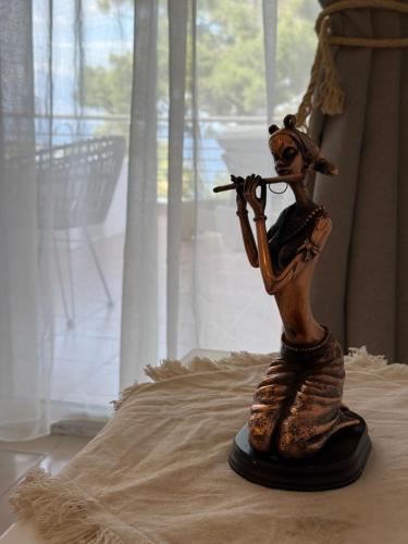 a statue of a woman playing a violin at Amelia Seaview Apartments & Studios in Kallithea Halkidikis