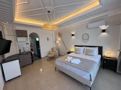 a bedroom with a large bed and a kitchen at Amelia Seaview Apartments & Studios in Kallithea Halkidikis