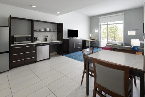 a kitchen and living room with a table and chairs at Home2 Suites by Hilton Greenville Downtown in Greenville