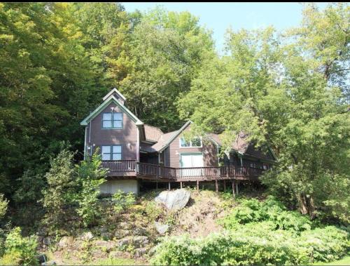 ein Haus auf einem Hügel mit Bäumen in der Unterkunft Tubing, Hiking and Jay Peak fun at the Cliff House in Montgomery