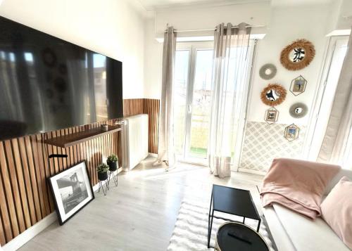 un salon avec un canapé et une grande fenêtre dans l'établissement - appartement-du-centre-ville, à Nice