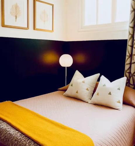 une chambre avec un lit avec des oreillers blancs et une fenêtre dans l'établissement - appartement-du-centre-ville, à Nice