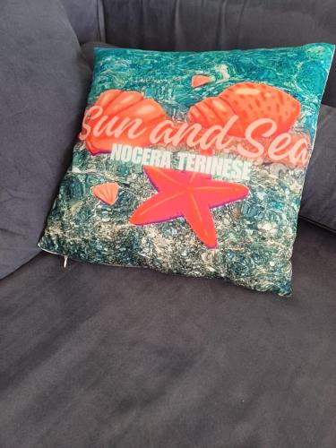 a pillow on a couch with a fish and sea merchandise at Appartamento Sun and Sea in Campora San Giovanni