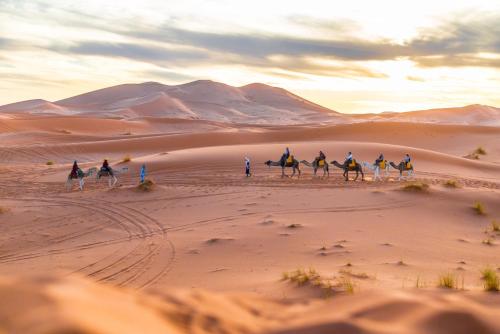 a group of people riding horses in the desert at Merzouga Luxury Dune Camp in Merzouga