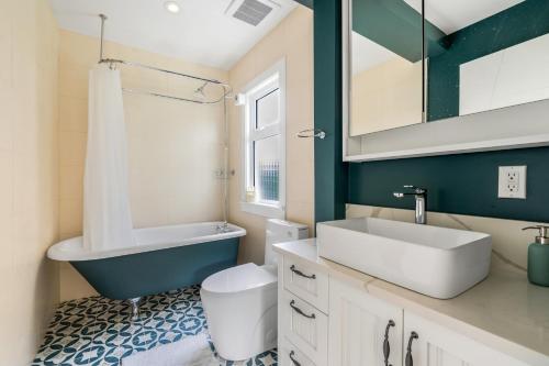 a bathroom with a sink and a toilet and a mirror at Comfort House in Kerrisdale Private and Shared Rooms in Vancouver