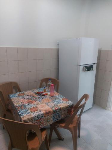 eine Küche mit Tisch und Kühlschrank in der Unterkunft Zoubeir's 3BR famille home-near shops&transport in tunis cité ettahrir in Bin Rhilouf
