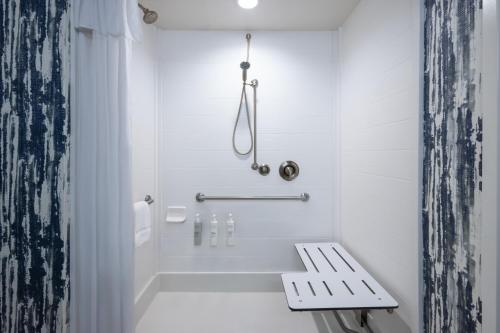 a white shower with a bench in a bathroom at Home2 Suites by Hilton Greenville Downtown in Greenville