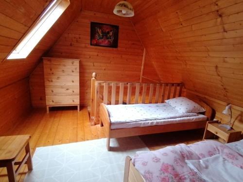 a bedroom with a bed in a wooden cabin at Domek dla rodziny in Jastarnia