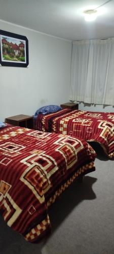 two beds in a hotel room with colorful blankets at HasREY in San Antonio