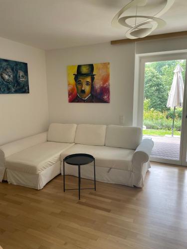 a living room with a white couch and a painting at Rose Garden Retreat Private Terrace Baden-Baden in Baden-Baden