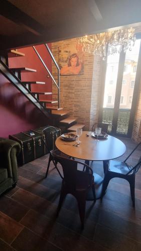 a dining room with a table and a staircase at Natalìa glamour home in Nettuno