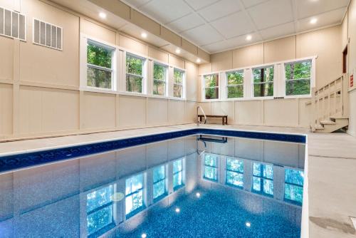 einen Pool in einem Haus mit Fenstern in der Unterkunft Wink Bear Lodge by Venture Smoky Mountains in Gatlinburg