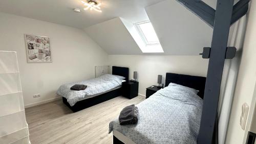 a attic bedroom with two beds and a skylight at Loft9 Architektenwohnung mit Dachterrasse Zentral in Lübeck