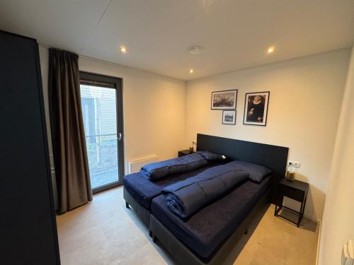 a bedroom with a large bed and a window at Enkhuizer Strand BeachHouse Panoramadeck mit Zaun Nr 415 in Enkhuizen