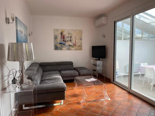 a living room with a couch and a tv at Maison arcachonnaise proche plage - animaux acceptés in Lanton