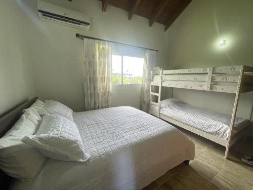 a bedroom with two bunk beds and a window at New! Chic Beach Condo at Punta Cana in Punta Cana