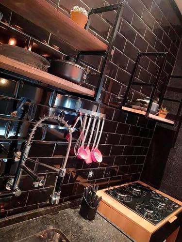 a kitchen with a stove and utensils on the wall at Loft Industrial in Santo André