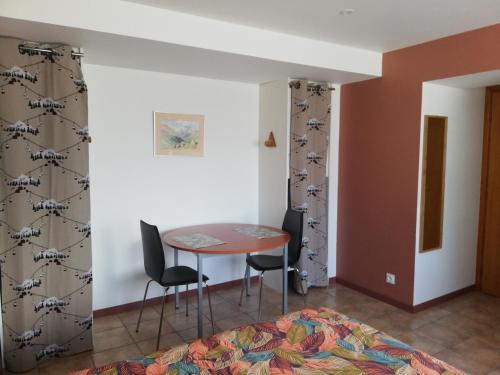 une pièce avec une table et deux chaises et un lit dans l'établissement Joli Studio, à La Celle-sous-Gouzon