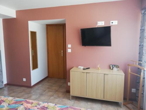 une chambre avec une télévision sur un mur et une armoire dans l'établissement Joli Studio, à La Celle-sous-Gouzon