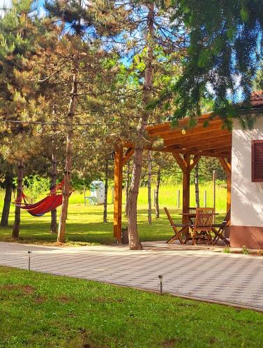 a picnic shelter with a hammock in a park at Kuća za odmor Čanić gaj in Gospić