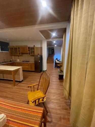 a kitchen and a living room with a table and chairs at Nathia Lodge Mountain View Hotel & Guest House Nathia Gali in Abbottābād