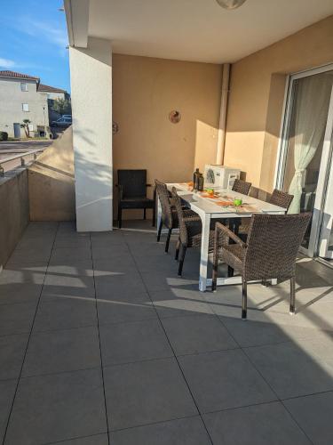 a patio with a table and chairs on a balcony at Joli cocon à Ajaccio avec terrasse vue mer in Ajaccio