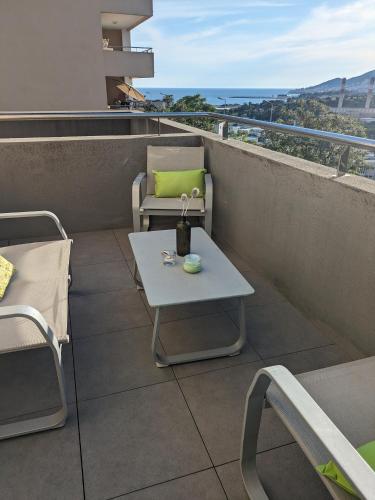 a patio with a table and chairs on a balcony at Joli cocon à Ajaccio avec terrasse vue mer in Ajaccio