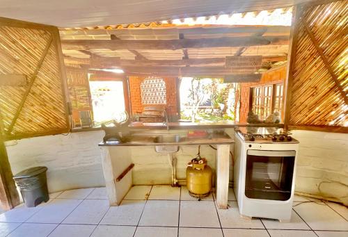 a kitchen with a sink and a stove in it at Shanti - Hospedagem e Vivências Terapêuticas in Sao Jorge