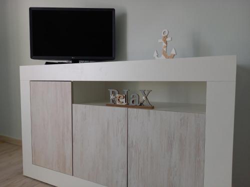 a tv on top of a tv stand with a tv at Domus DELEDDA in Posada
