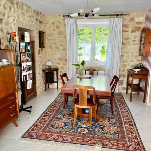 une salle à manger avec une table et des chaises en bois dans l'établissement La Maison de la Hulotte, à Golleville