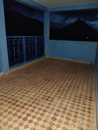 a room with a tiled floor and a balcony at Riad Dar Amgdoule Tacheddirt in Tacheddirt