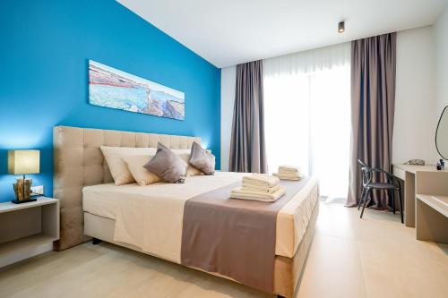 a bedroom with blue walls and a large bed at Villa View in Ugrinići