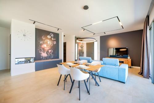 a living room with a table and a blue couch at Villa View in Ugrinići