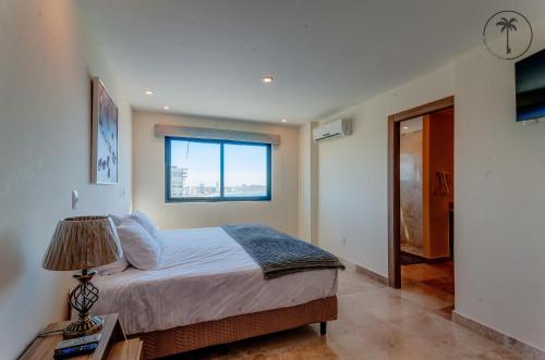 a bedroom with a large bed and a window at Lujoso residencial con amenidades únicas in Mazatlán