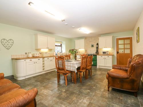 a kitchen with a table and chairs in a room at Yr Hen Stabl in Caernarfon