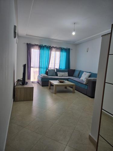 a living room with a couch and a table at Atlantique Assilah Locations de Vacances in Asilah