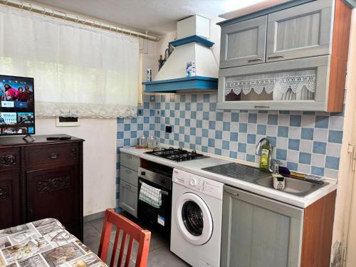 a kitchen with a washing machine and a sink at Ottocento - Casa Brunori in Follonica