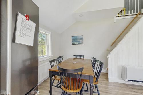 a dining room with a wooden table and chairs at Hobby Hops Farmhouse in Northport