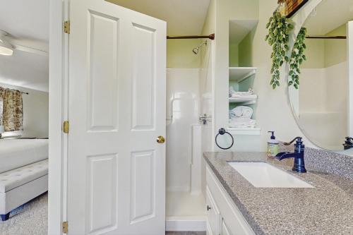 a white bathroom with a sink and a mirror at Hobby Hops Farmhouse in Northport