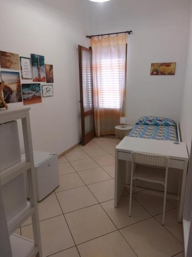 a room with a table and a bed in it at B&B Coccinelle in San Vito lo Capo