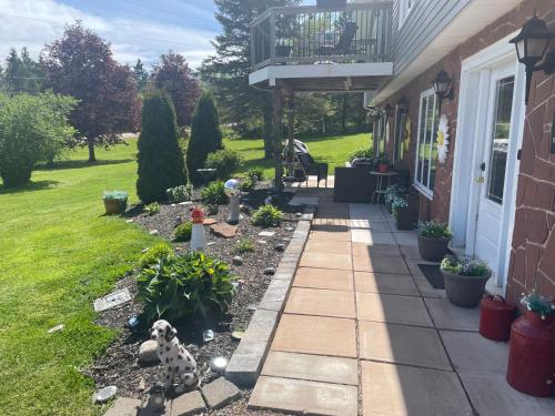 a dog sitting on a walkway next to a house at Rose Valley Suites in Prince Edward Island