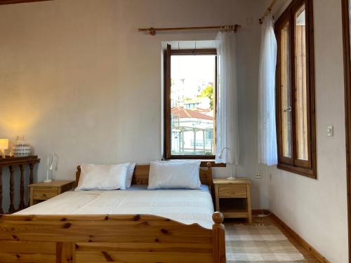 a bedroom with a wooden bed and a window at Adele house in Skopelos Town