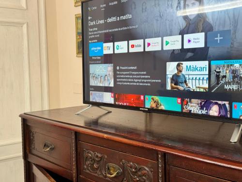 a flat screen tv sitting on top of a wooden dresser at Ottocento - Casa Brunori in Follonica