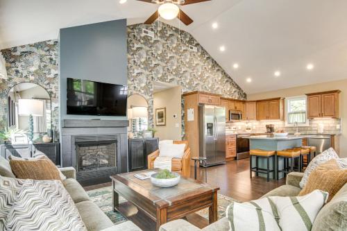 a living room with a fireplace and a kitchen at Walk to Dtwn Waynesville Home with Deck! in Waynesville