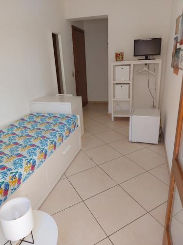a small bedroom with a bed and a tv at B&B Coccinelle in San Vito lo Capo