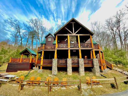 een groot huis met een omlopend terras met stoelen bij Hidden Haven by Venture Smoky Mountains in Gatlinburg
